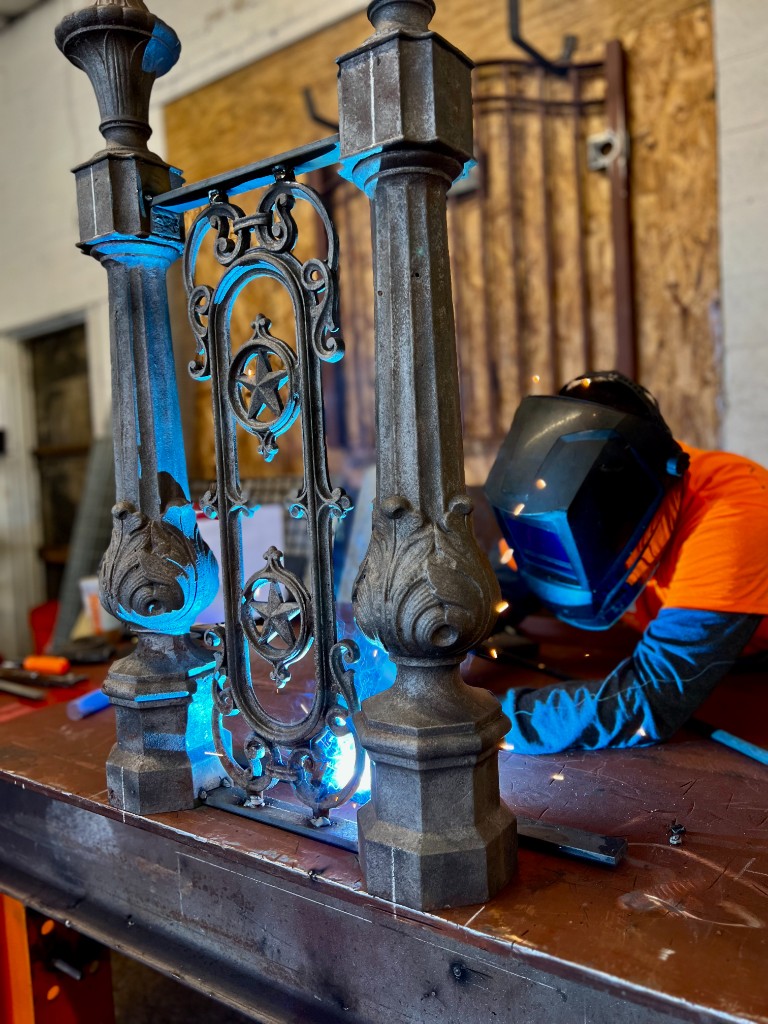 Historic ornamental iron railing during in-shop welding repair — specialty restoration